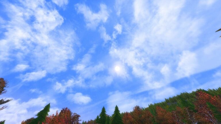 Ciel bleu nuageux au-dessus de forêt colorée.