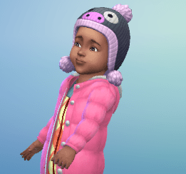 Bebé con abrigo rosa y gorro de pingüino.