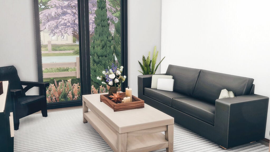 Salon moderne, canapé noir, vue arbre florissant.