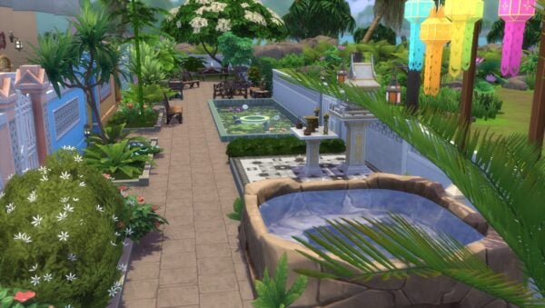 Jardin tropical avec fontaine et lanternes colorées.