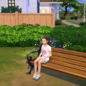 Jeune Sim assise sur un banc dans un jardin verdoyant
